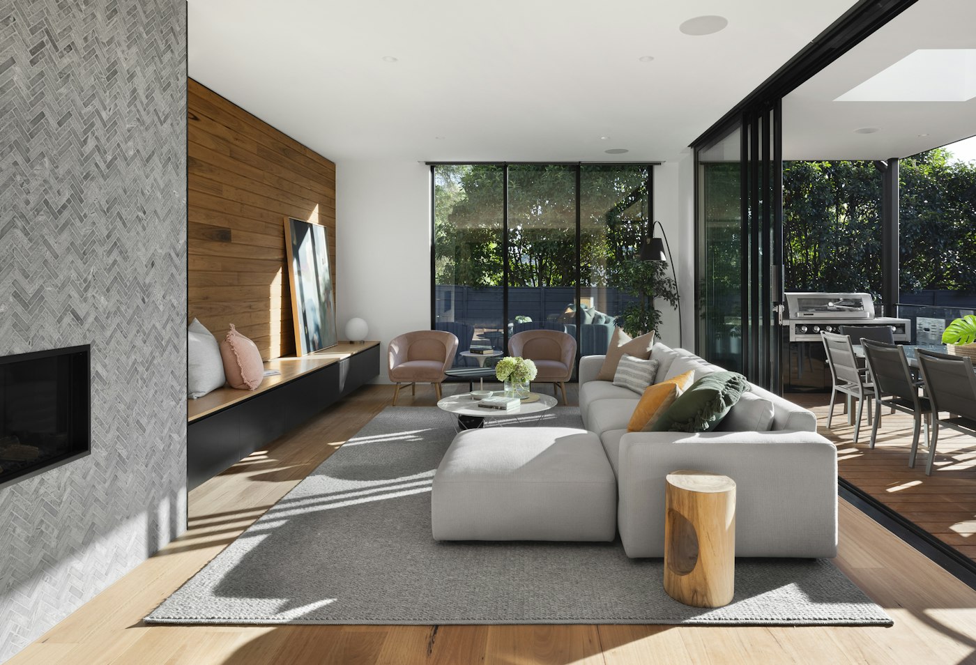 Extended open-plan living room with timber panelling flowing out to a garden deck