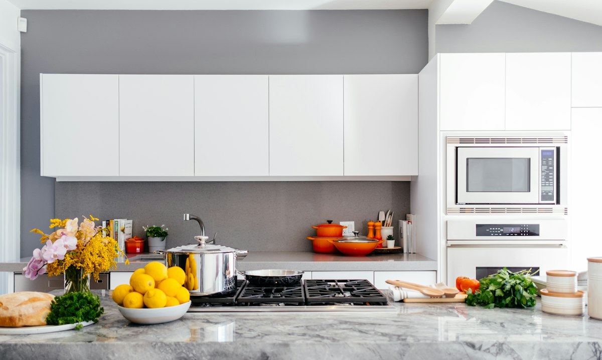 Contemporary kitchen renovation with marble island, grey cabinetry and brass accents